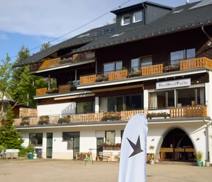 Außenansicht des Landhotels Fuchs mit Balkon und weißer Werbefahne