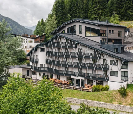 Modernes Hotel in den Bergen mit Terrasse und dichter Begrünung