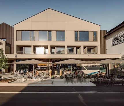 Außenansicht von Dips & Drops Bistro mit Terrasse und Gästen bei Sonnenlicht