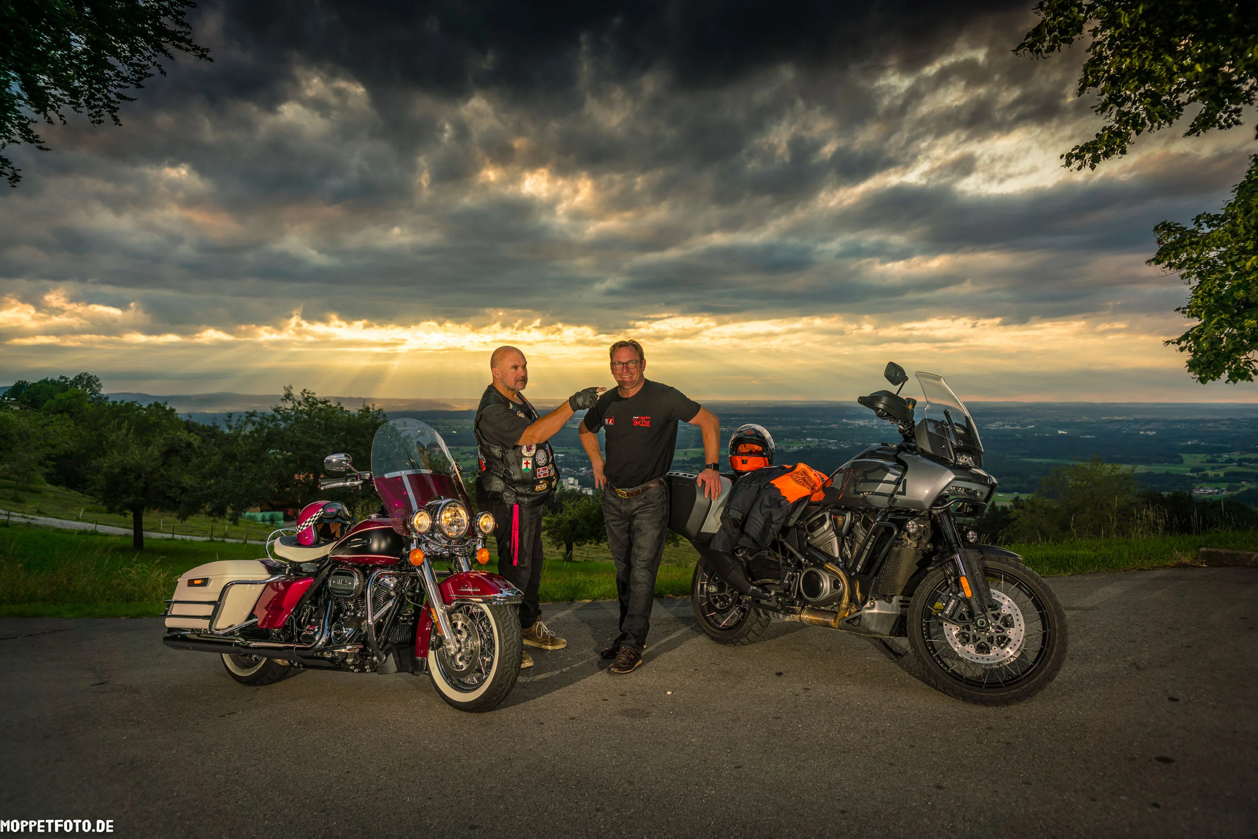MoHo - Motorrad Hotels © Moppetfoto.de Zwei Männer mit Motorrädern bei Sonnenuntergang auf einer Landstraße