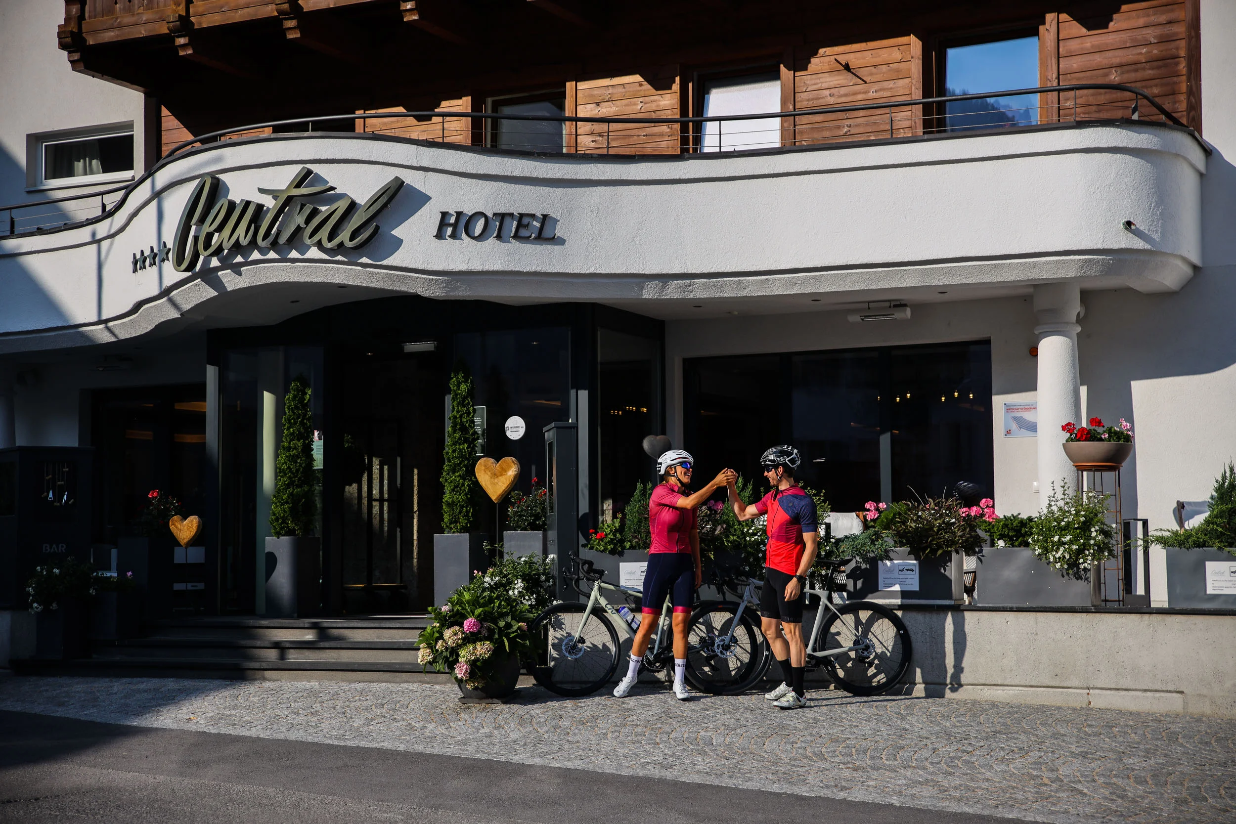 Roadbike Holidays © Felix Saller Zwei Radfahrer klatschen vor dem Central Hotel ab