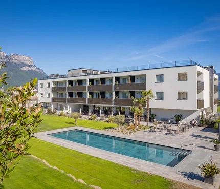 Modernes Wohngebäude mit Pool und Blick auf Berglandschaft bei klarem Himmel