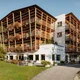 Hotel Melodia del Bosco mit Holzfassade und Blumen auf Balkonen im Grünen