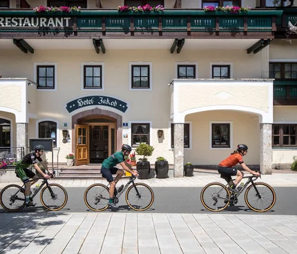 Drei Radfahrer vor Hotel Jakob bei sonnigem Wetter