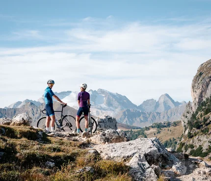 Zwei Radfahrer mit Helm in den Bergen auf einem felsigen Pfad