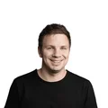 Porträt eines lächelnden Mannes mit schwarzem T-Shirt vor weißem Hintergrund