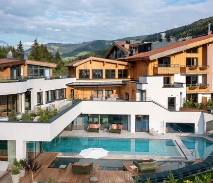 Modernes Hotel mit Außenpool und Bergblick bei klarem Himmel