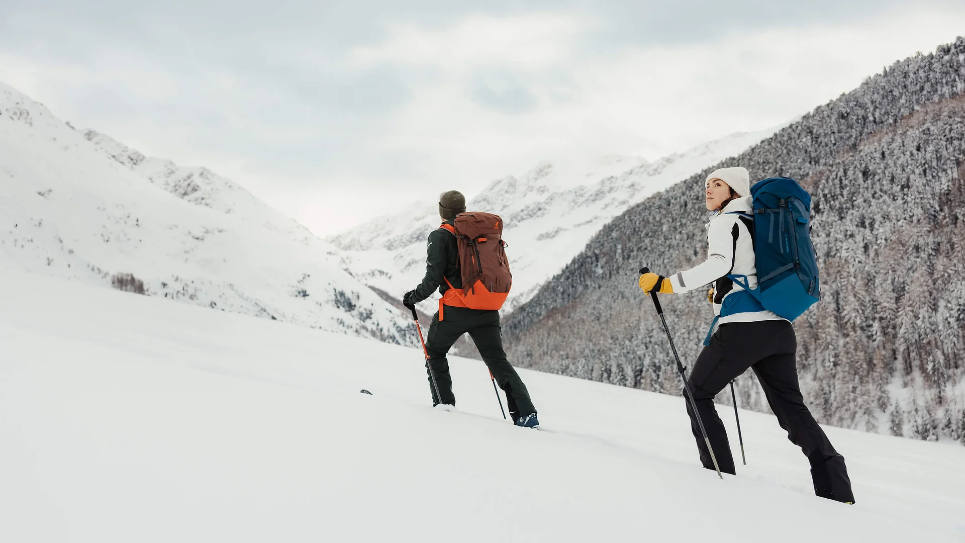 Langlauf & Skitourenhotel © Alex Moling Zwei Wanderer mit Rucksäcken wandern im verschneiten Berggebiet