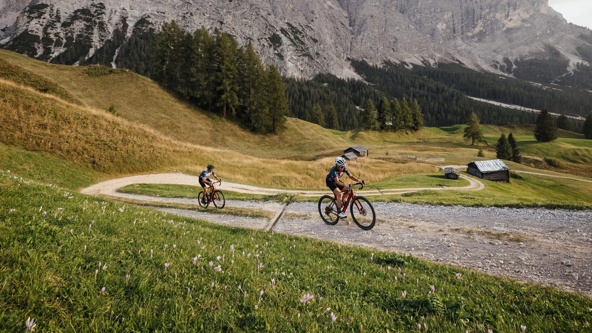Gravelbike Holidays © Alex Moling Zwei Radfahrer auf einem Bergweg mit Alpen im Hintergrund